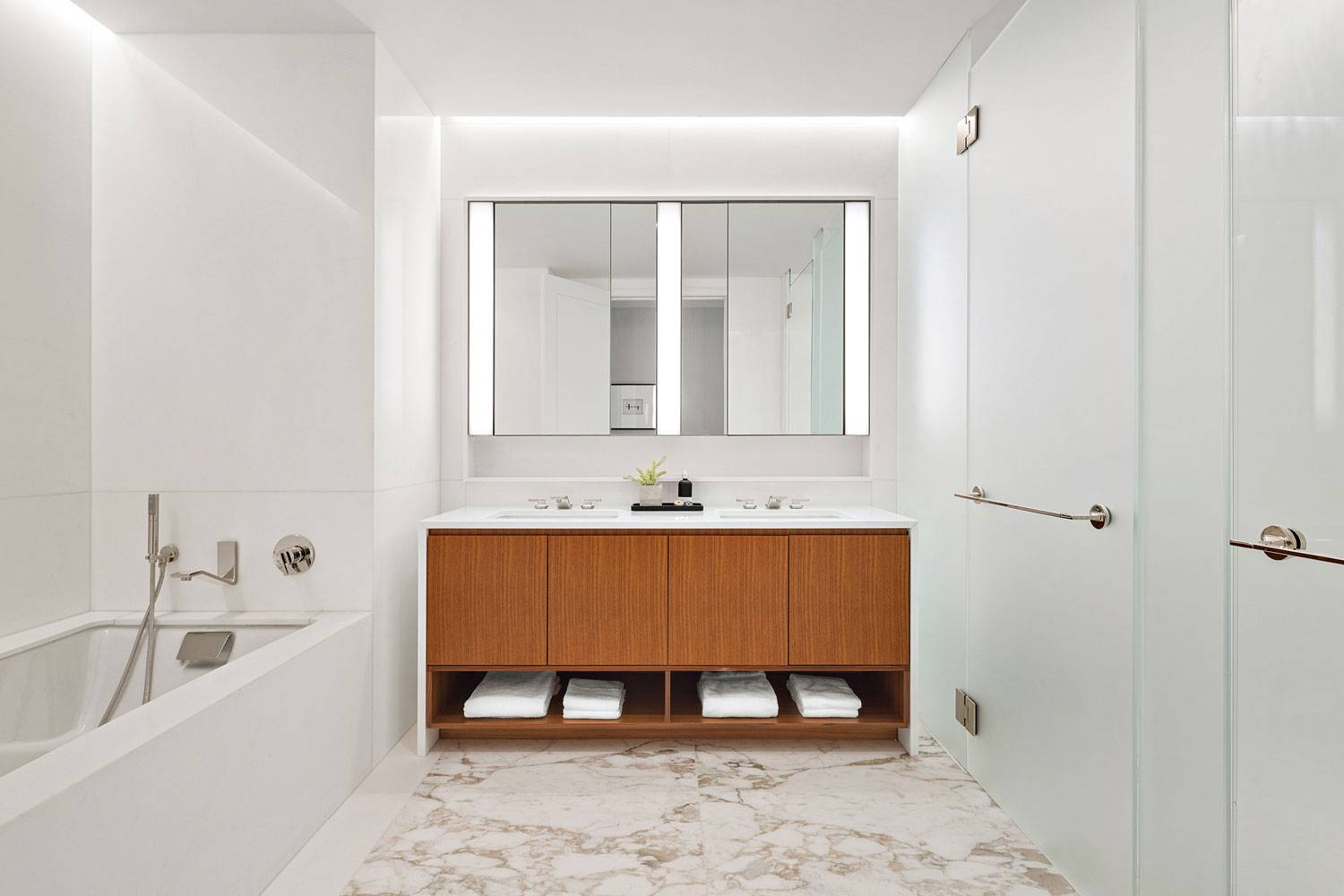 1289 Lexington spacious bathroom with bathtub and private shower and powder room. Double sinks and custom vanity with lighting.