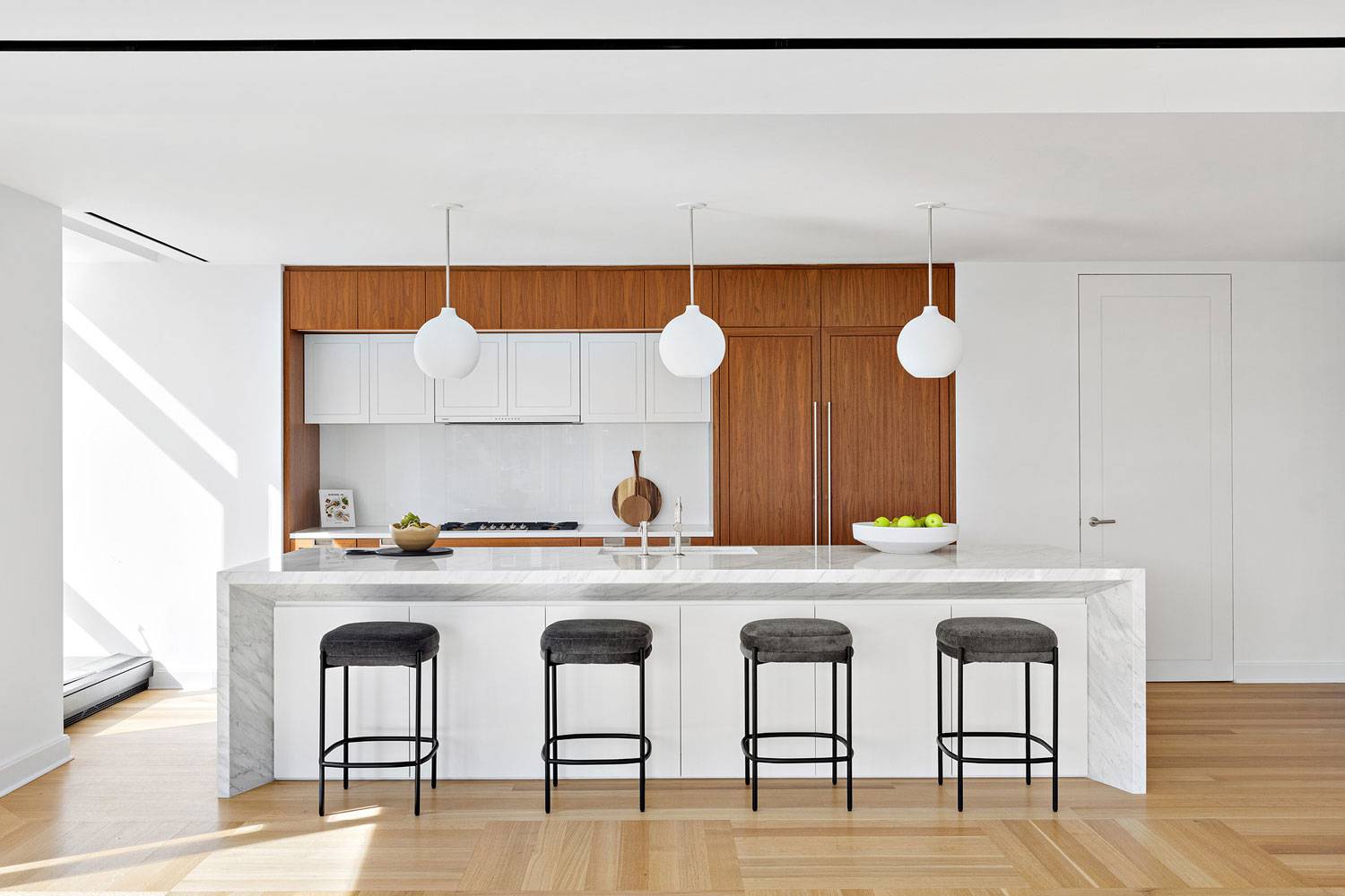 1289 Lexington kitchen with wood cabinetry and center marble island with seating.